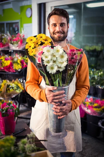 Male florist holding flower bouquet at flower shop — Stock Photo, Image