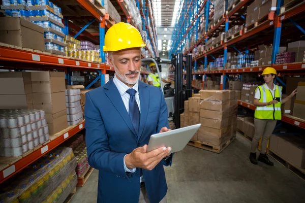 Enfoque del gerente es el uso de una tableta y usar un sombrero duro — Foto de Stock