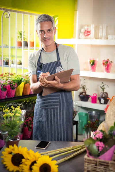 Mannlig blomsterhandler på skriveplate – stockfoto