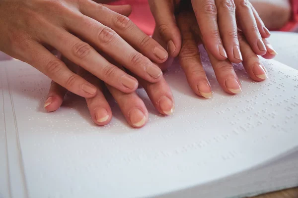 Krankenschwester hilft Seniorin mit Blindenschrift — Stockfoto