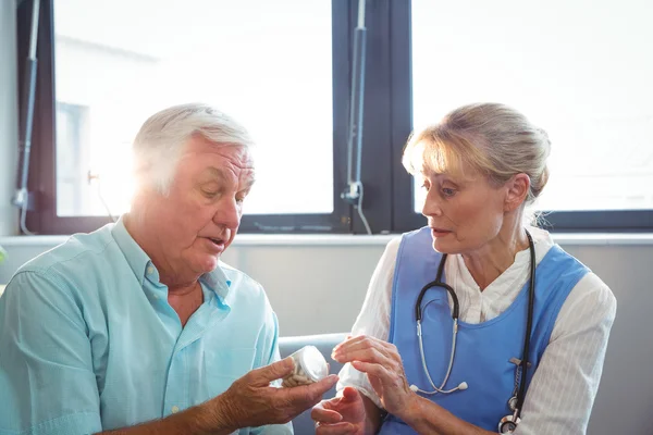 Verpleegkundige en senior man met geneeskunde — Stockfoto