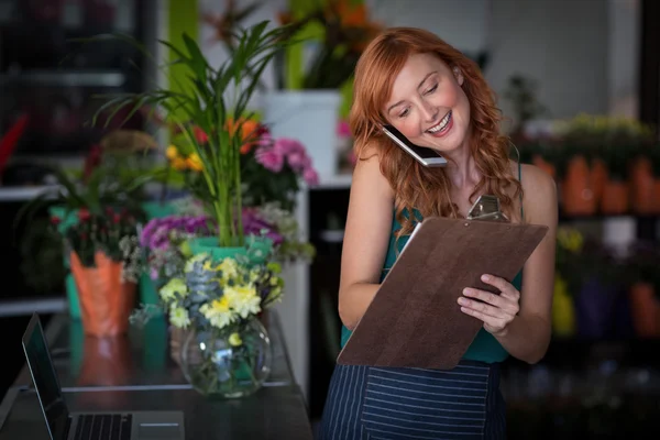 Floristin nimmt Bestellung per Handy entgegen — Stockfoto