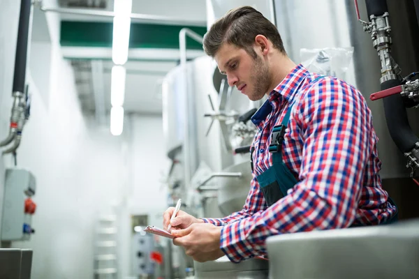 Maintenance worker writing on clipboard — Stock Photo, Image