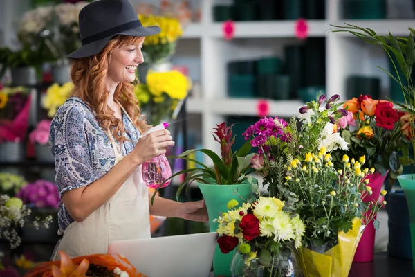 Флористи обприскують воду на квіти в квітковому магазині — стокове фото