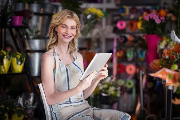 Lachende vrouw bloemist met behulp van digitale tablet — Stockfoto