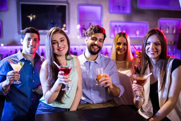 Amici che mostrano cocktail al bancone del bar — Foto Stock