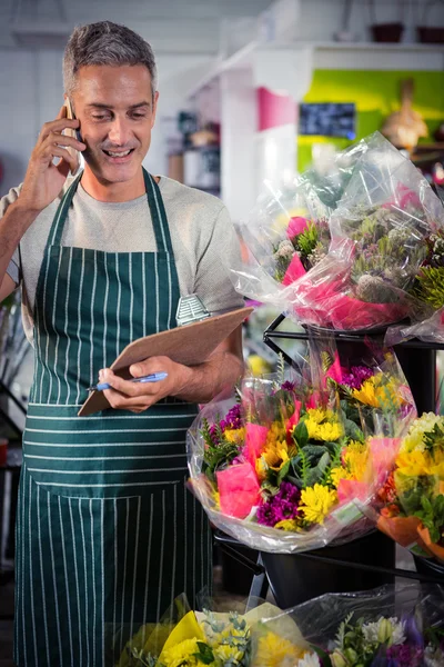 Floristería masculina tomando el orden en el teléfono móvil —  Fotos de Stock