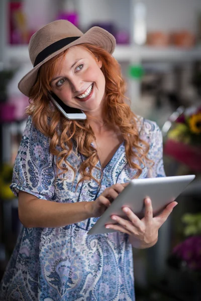 Vrouwelijke bloemist praten op mobiele telefoon — Stockfoto