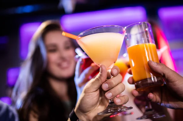 Друзья пьют коктейль за барной стойкой — стоковое фото