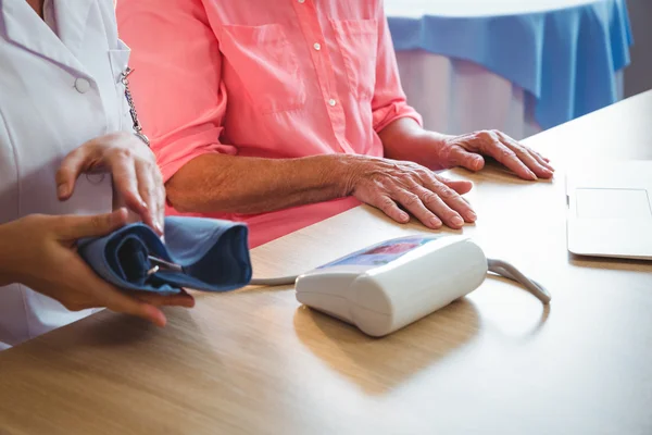 Infermiera che misura la pressione sanguigna di una donna anziana — Foto Stock