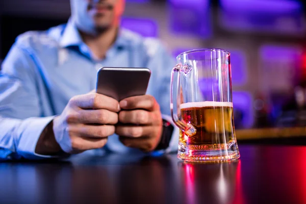 Man använder mobiltelefon på bardisk — Stockfoto