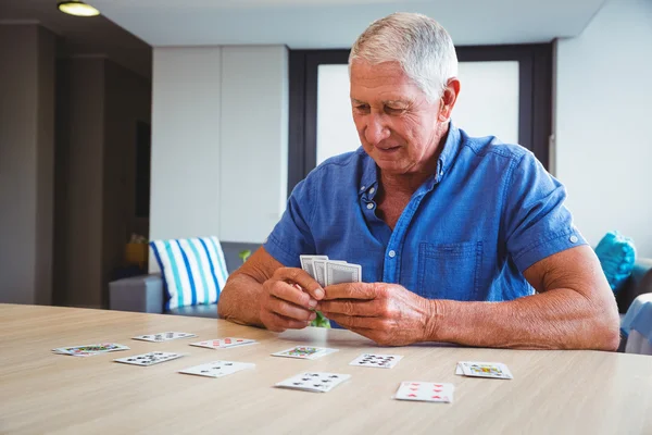 Starší muž hrací karty — Stock fotografie