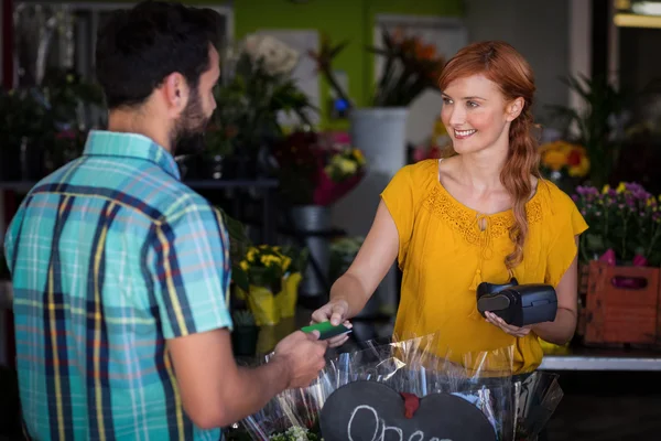 Man die met zijn credit card betaling aan vrouwelijke bloemist — Stockfoto