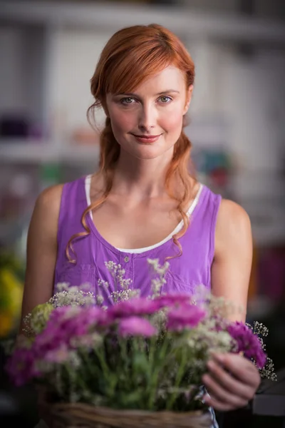 Ženské květinářství drží košík s květinami — Stock fotografie