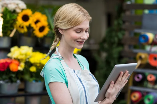 Vrouwelijke bloemist met behulp van digitale Tablet PC in de winkel van de bloemist — Stockfoto