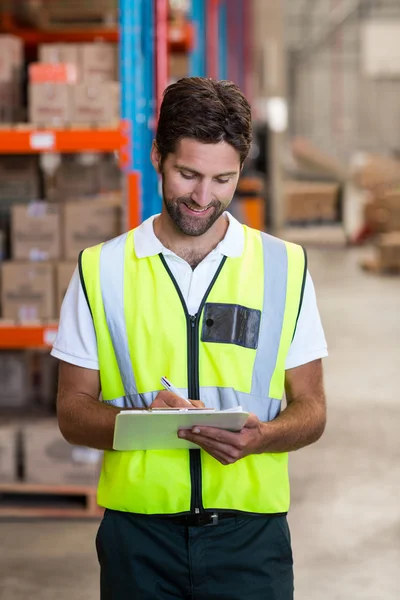 Portrait of worker is writing on clipboard — Stock Photo, Image