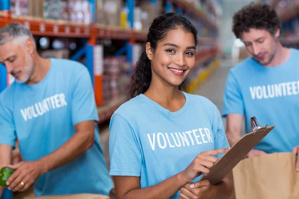 Retrato de voluntário feliz está posando e segurando uma área de transferência — Fotografia de Stock