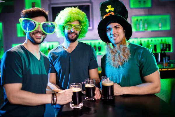 Masculino amigos sorrindo e segurando cerveja canecas — Fotografia de Stock