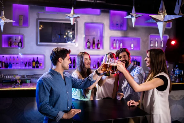 Amis toasting verres de bière au comptoir du bar — Photo