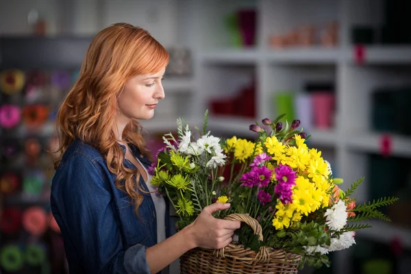 Blumenhändlerin hält Korb mit Blumen — Stockfoto