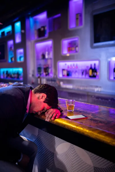 Uomo depresso che beve whisky al bancone del bar — Foto Stock