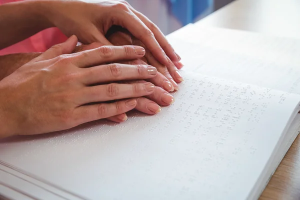 Krankenschwester hilft Seniorin mit Blindenschrift — Stockfoto