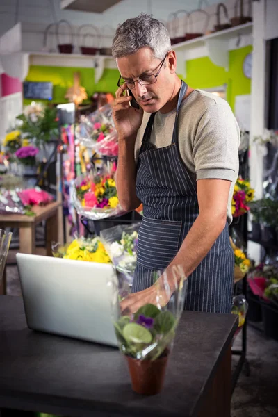 Floristería masculina tomando el orden en el ordenador portátil —  Fotos de Stock