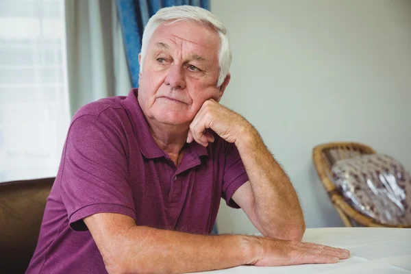 Senior man sitting at a table — Stock Photo, Image