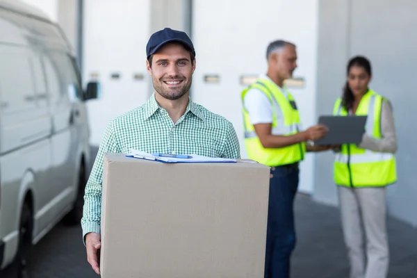 Focus of delivery man is holding a cardboard box — Stock Photo, Image