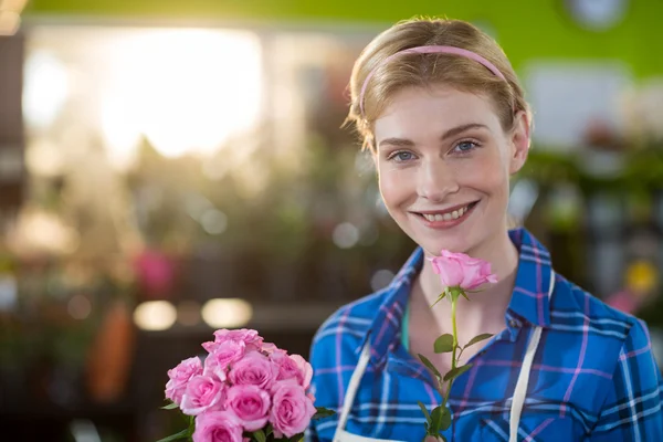 Fiorista femminile che tiene mazzo di fiore in negozio di fiori — Foto Stock
