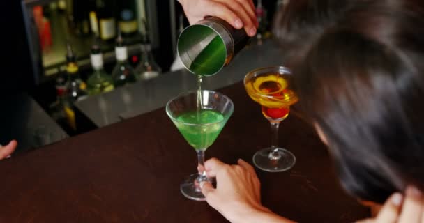 Barman ten dienste staat een cocktail aan vrouw — Stockvideo