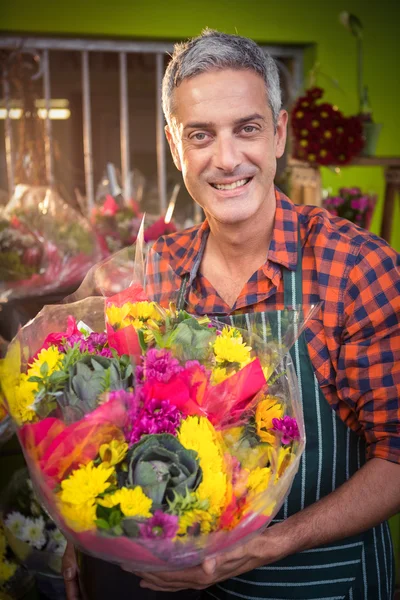 Kwiaciarnia mężczyzna trzymając kwiat bukiet w kwiaciarni — Zdjęcie stockowe