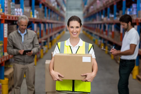 Focus on worker is holding cardboard box and smiling — Stock Photo, Image