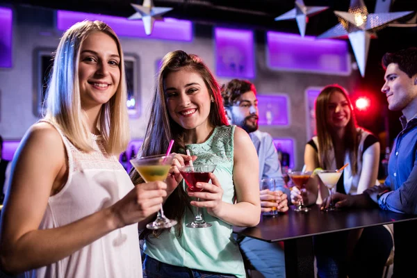 Amigos tomando un cóctel en el mostrador del bar —  Fotos de Stock