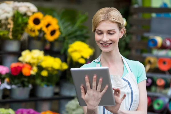 Floristería femenina usando tableta digital — Foto de Stock