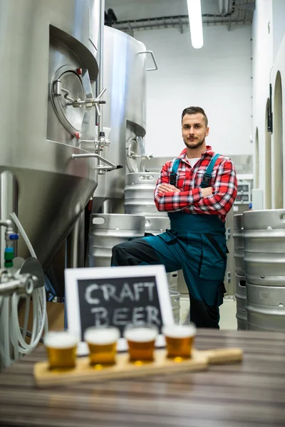 Quatre verres de bière artisanale sur plateau échantillonneur de bière et stand brasseur — Photo