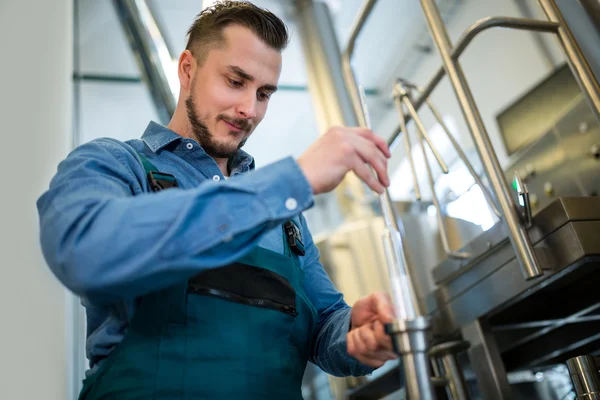 Cervecera comprobando cerveza con hidrómetro —  Fotos de Stock