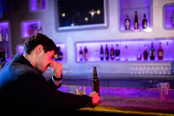 Uomo depresso che beve birra al bancone del bar — Foto Stock