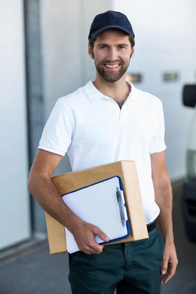 Portrait of delivery man is holding cardboard box — Stock Photo, Image