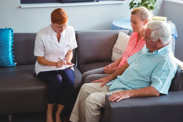 Nurse writing on clipboard — Stock Photo, Image