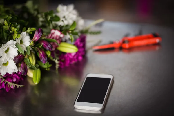 Flores y smartphone sobre la mesa —  Fotos de Stock