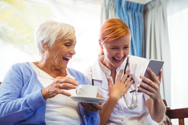 Femme âgée et infirmière utilisant une tablette numérique — Photo