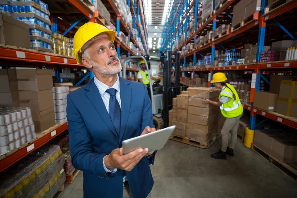 Portret van manager is bezit van een tablet en opzoeken — Stockfoto