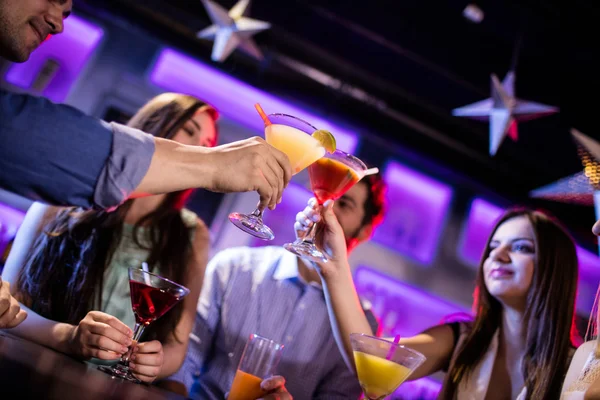 Freunde prosten Cocktail an der Theke zu — Stockfoto