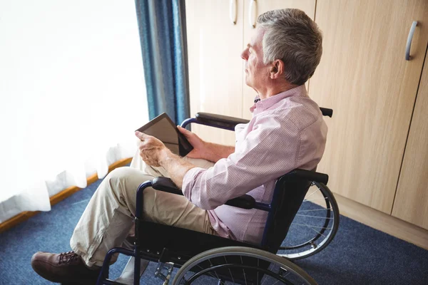 Homem sênior usando um tablet digital — Fotografia de Stock