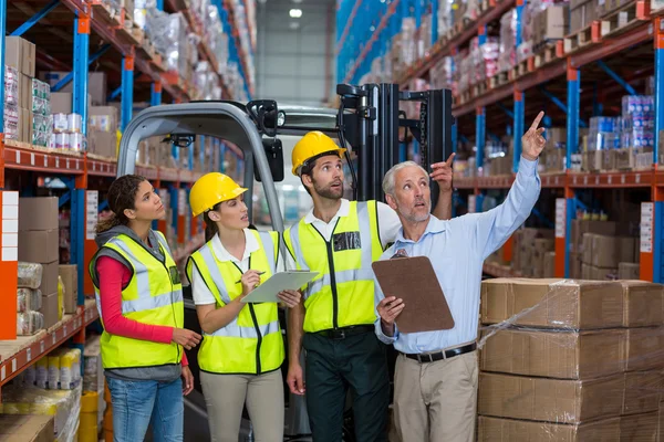 Manager e lavoratori sono alla ricerca di scaffali e puntando — Foto Stock