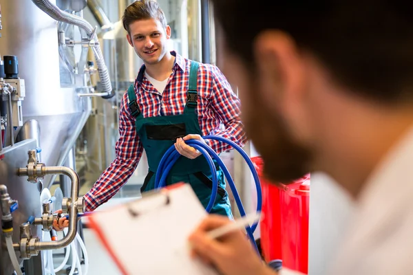 Travailleurs d'entretien examinant la machine de brasserie — Photo