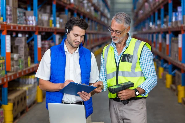 Compañero de trabajo mirando tableta digital en almacén — Foto de Stock