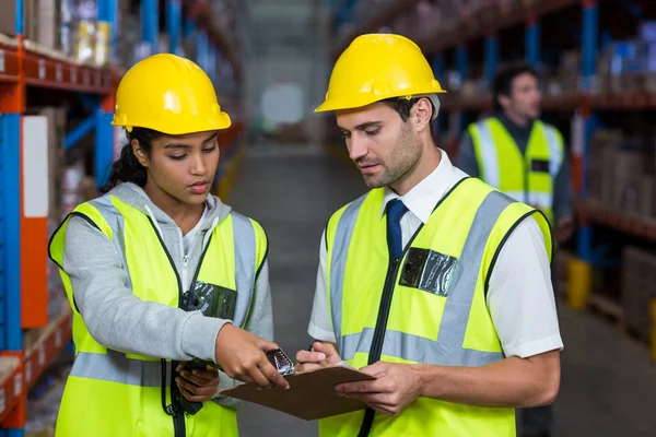 Trabajadores mirando el portapapeles — Foto de Stock