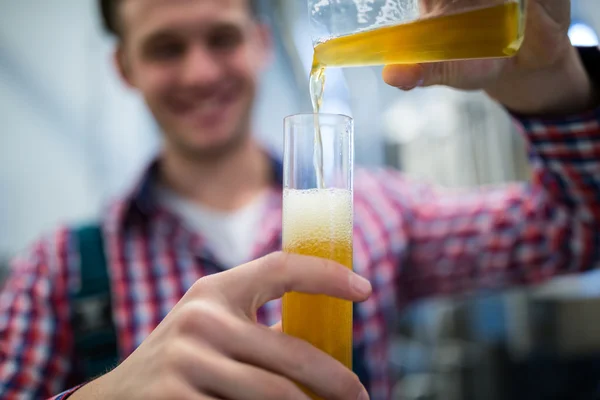 Brewer pouring beer in hydrometer cylinder — Stock Photo, Image